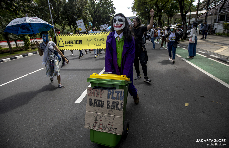 A protester wearing a Joker costum joins the long march againts climate crisis in front of Jakarta City Hall on Friday (27/11). (JG Photo/Yudha Baskoro)