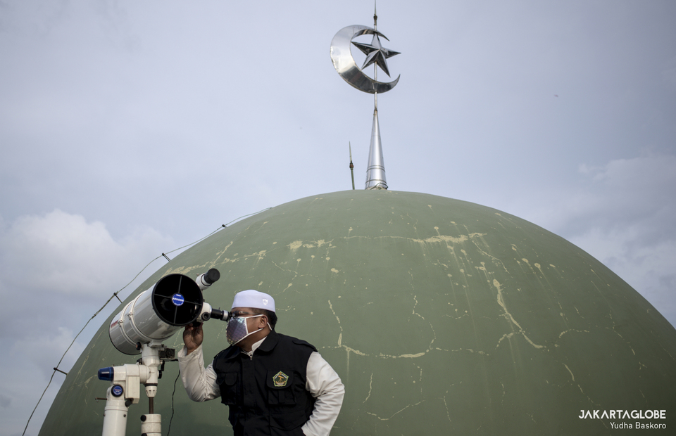 A muslim cleric tries to get an early view the moon up on the roof of the Al Musariin mosque in West Jakarta before the first day of Ramadan on April 23, 2020. (JG Photo/Yudha Baskoro)