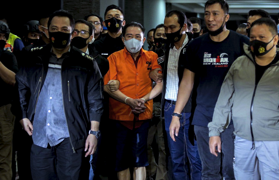 Graft fugitive Djoko Tjandra, center, is escorted by police officers upon arrival at the Halim Perdanakusumah Airport in East Jakarta after a flight from Kuala Lumpur on July 30, 2020. (Beritasatu Photo/Joanito De Saojoao)