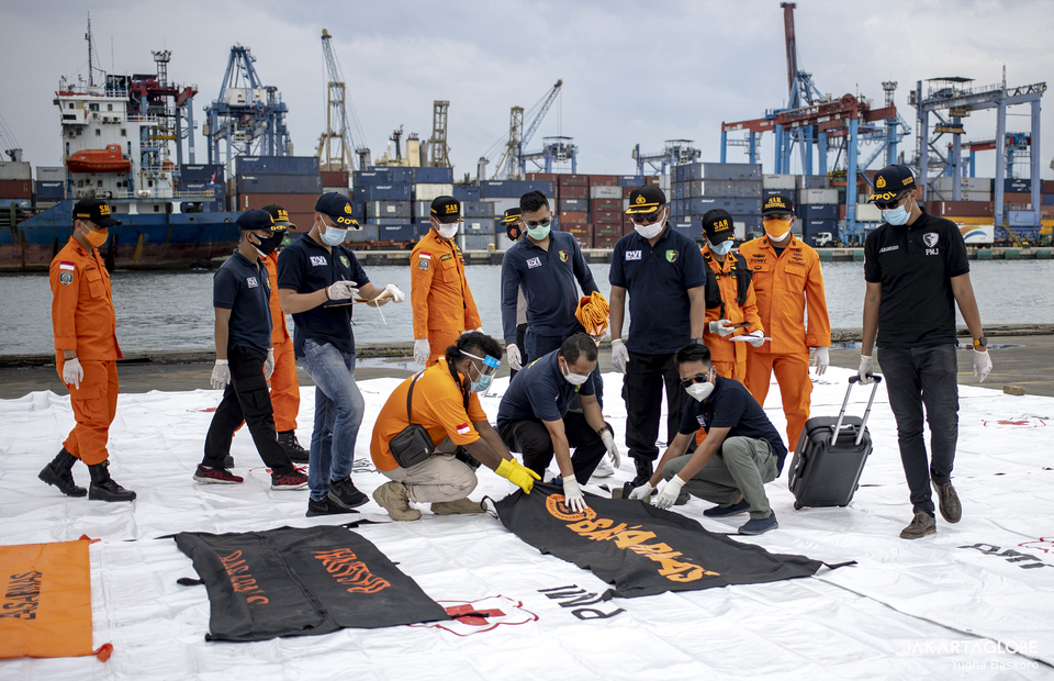 National Police Disaster Victims Identification team inspect bags contain body part of a Boeing 737-500 crash victims at the Tanjung Priok in North Jakarta on Jan, 10, 2021. (JG Photo/Yudha Baskoro)