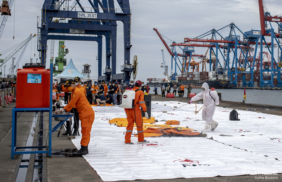 Indonesian Red Cross personnels sprays body bag contain Boeing 737-500 crash victims at the Tanjung Priok in North Jakarta on Jan, 10, 2021. (JG Photo/Yudha Baskoro)