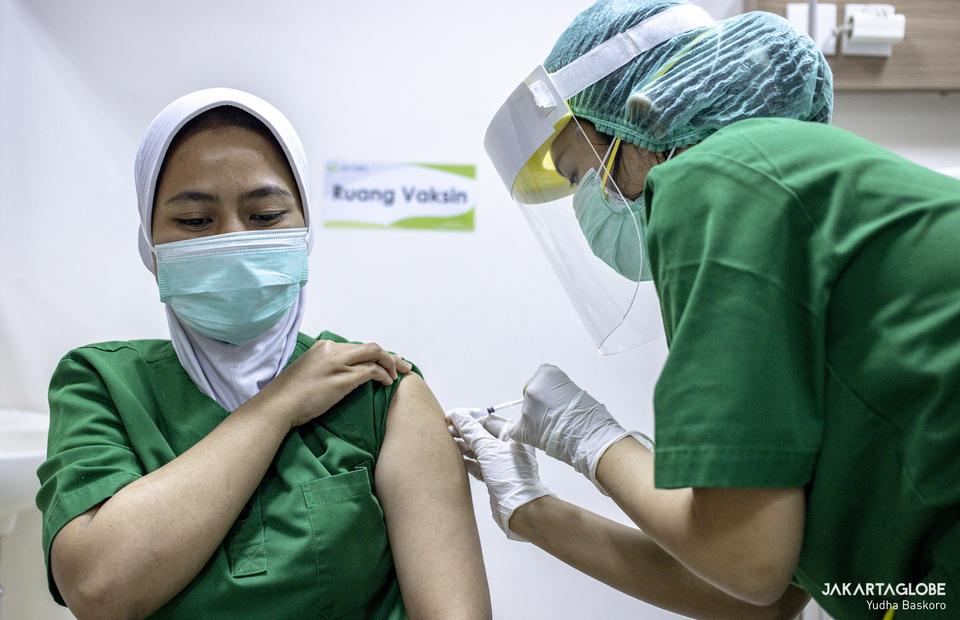 A health worker receives COVID-19 vaccine at RSIA Tambak in South Jakarta on Jan, 15, 2021. (JG Photo/Yudha Baskoro)