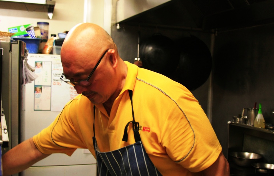 Benny Lim, one of the owners of Manise Cafe and a professional chef, cooks in the restaurant