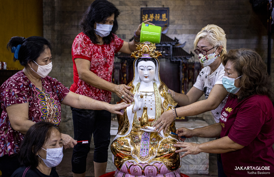 Women take care of a statue of Dewi Kwan Im at Armurva Bhumi Temple (Hok Tek Tjeng Sin) at Karet Semanggi, in South Jakarta, on Feb, 4, 2021 in preparation for Chinese New Year. Kwan Im is a symbol of goodness, beauty and generosity for women. (JG Photo/Yudha Baskoro)