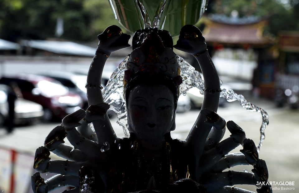 A worshiper wash a statue with clean water at Armurva Bhumi Temple (Hok Tek Tjeng Sin) at Karet Semanggi, in South Jakarta, on Feb, 4, 2021 in preparation for Chinese New Year. (JG Photo/Yudha Baskoro)