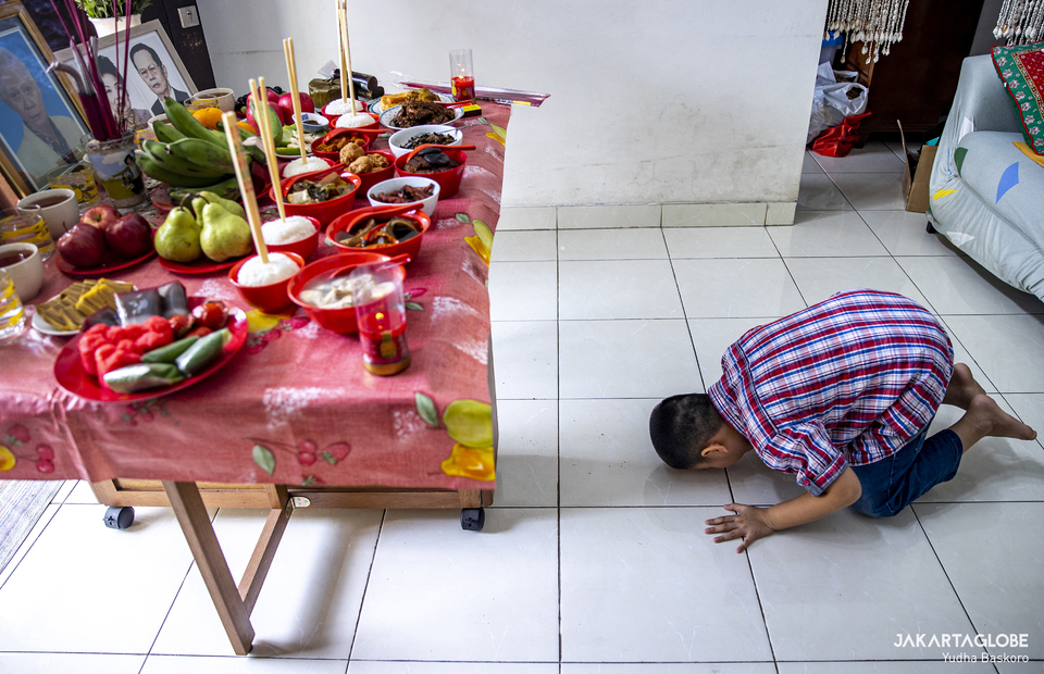 Daniel kneels as he prays for his late great grandparents at South Tangerang, Banten on Feb 11, 2021. (JG Photo/Yudha Baskoro)
