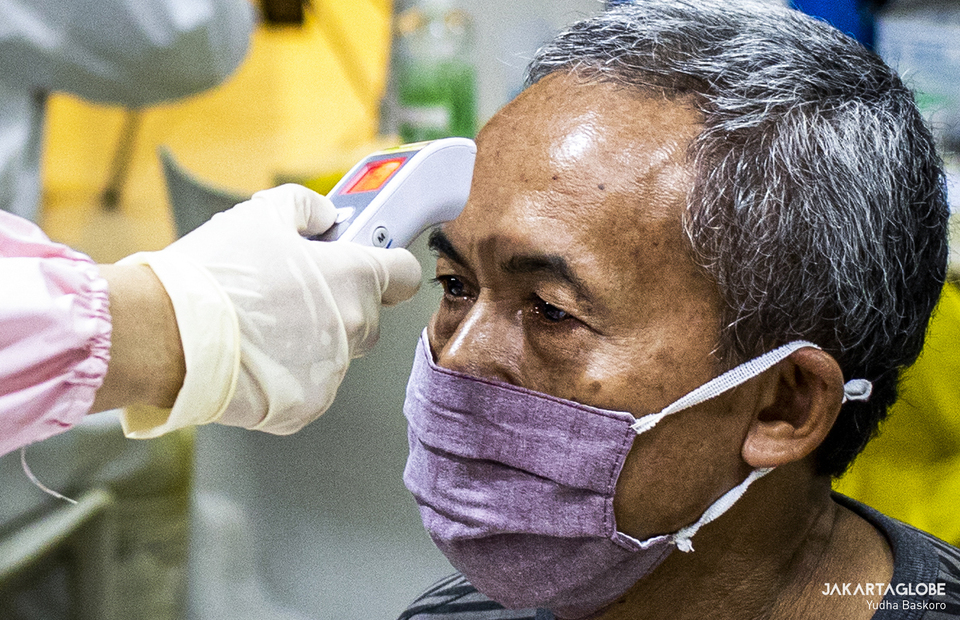 A trader of Tanah Abang market has his body temperature measured during second phase of COVID-19 mass vaccination in Tanah Abang market, Central Jakarta on Feb 17, 2021. (JG Photo/Yudha Baskoro)