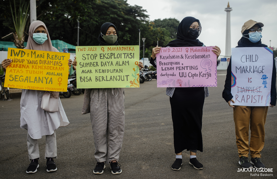 Womens March participants carry posters with slogans criticized gender-based violence, rape culture and some women worker related issues in Indonesia during International Women