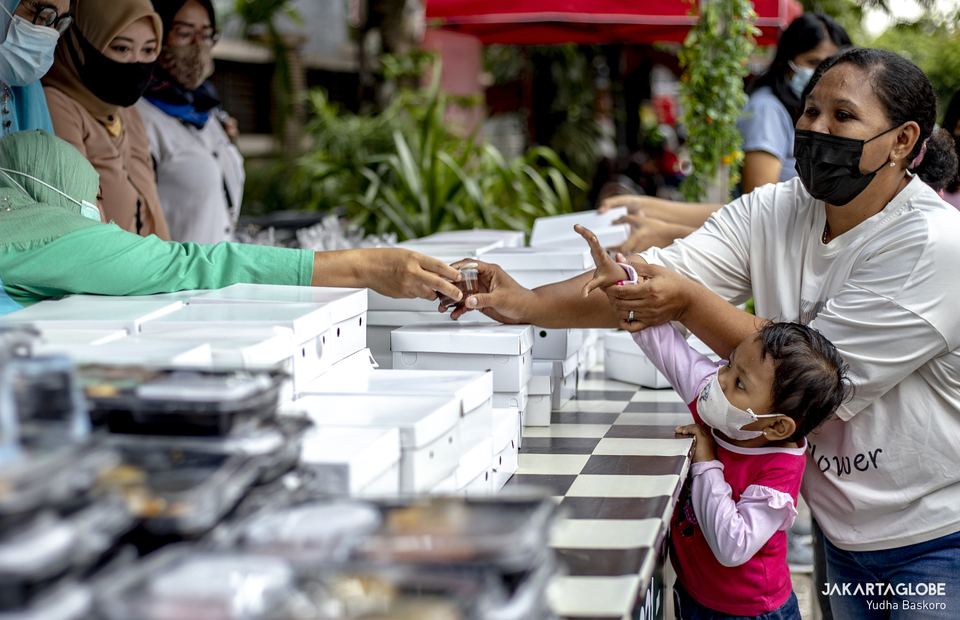 A child gets a free iftar meal in Cempaka Putih, Central Jakarta, on April 19, 2021. (JG Photo/Yudha Baskoro)