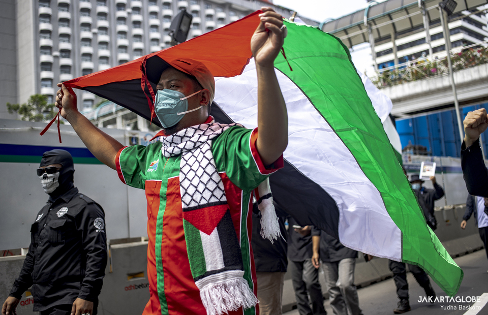 A protester waves a Palestinian flag during protest against Israel outside United Nations building in Central Jakarta on May 18, 2021. (JG Photo/Yudha Baskoro)