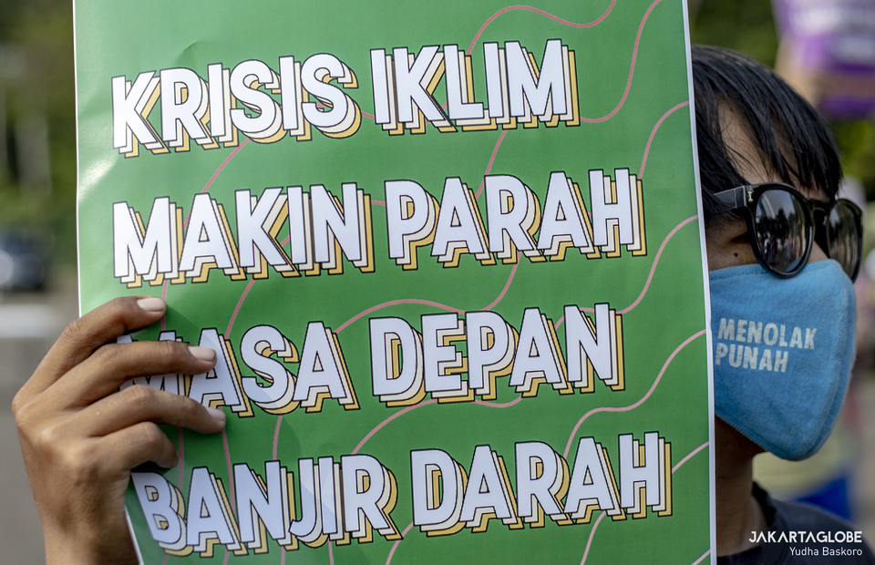An environmental activist carries placard during protest against climate crisis in Central Jakarta on June 4, 2021. (JG Photo/Yudha Baskoro)