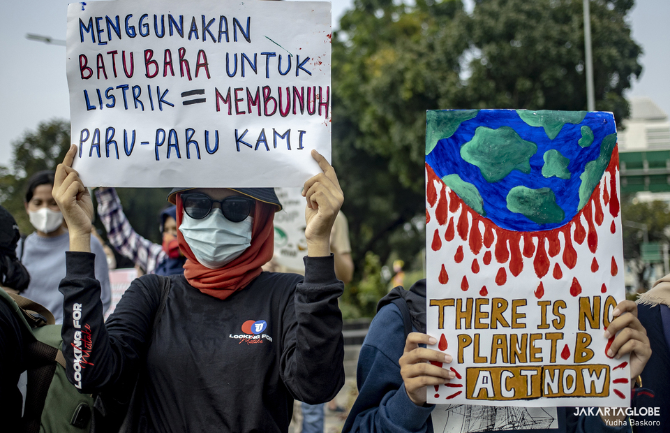 Protesters carry placard during protest against climate crisis in front of M.H. Thamrin statue in Central Jakarta on June 4, 2021. (JG Photo/Yudha Baskoro)