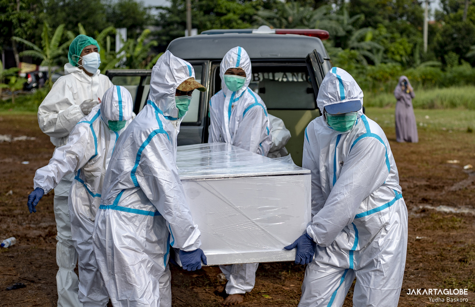 Funeral service workers in their protective gears carry the coffin of suspect Covid-19 patient in Padurenan Cemetery in Bekasi, West Java on June 18, 2021. (JG Photo/Yudha Baskoro)