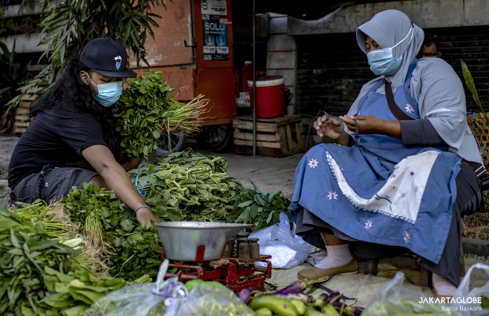 Adrian Reza buys some vegetables from small trader at Pasar Legi, in Solo, Central Java on July 31, 2021. (JG Photo/Yudha Baskoro)