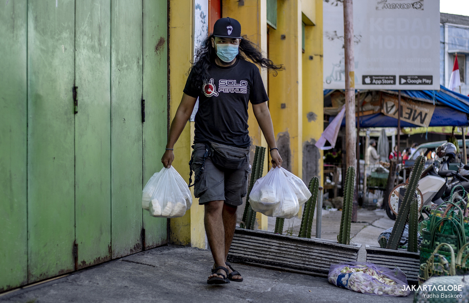 Adrian Reza walks as he collects some vegetables from small traders around Pasar Legi, in Solo, Central Java on July 31, 2021. (JG Photo/Yudha Baskoro)