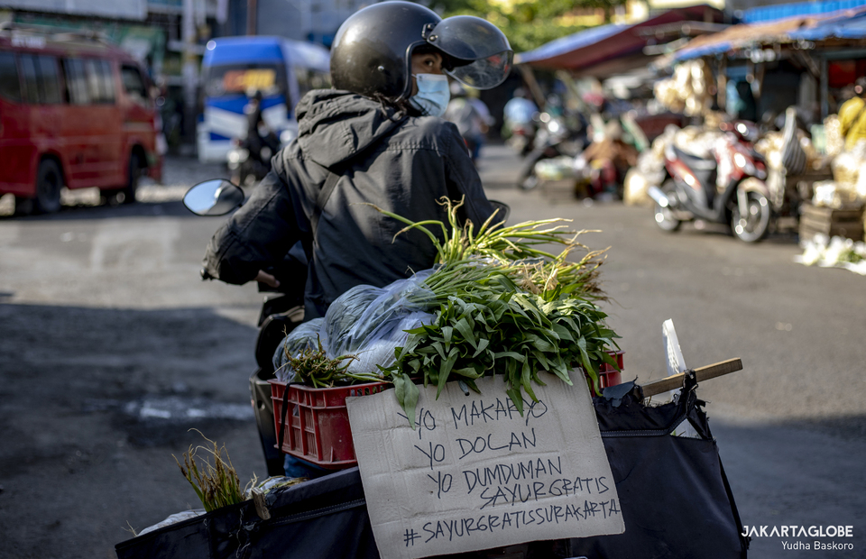 A volunteer of Sayur Gratis Surakarta rides his bike carrying vegetables at Pasar Legi, in Solo, Central Java on July 31, 2021. (JG Photo/Yudha Baskoro)