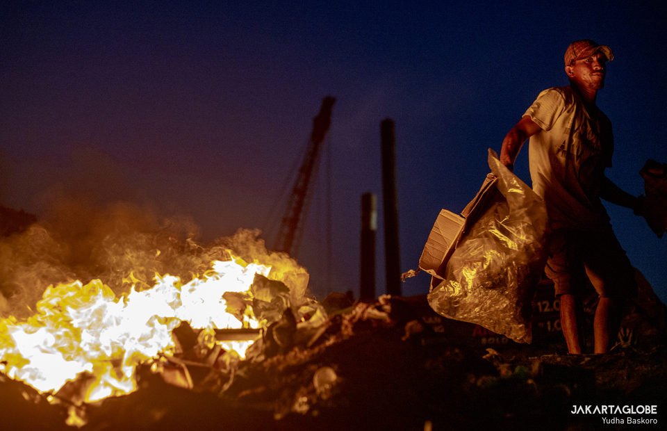 A man sets up a fire during a night at Muara Baru, North Jakarta on August 12, 2021. (JG Photo/Yudha Baskoro)