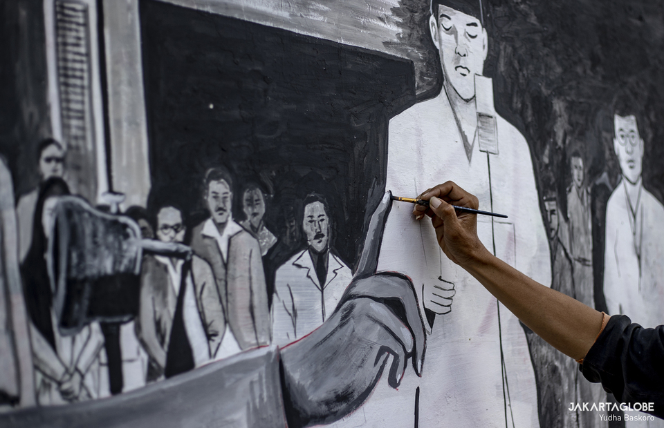 Gunawan paints a mural at Tebet fly over in South Jakarta on August 15, 2021. (JG Photo/Yudha Baskoro)