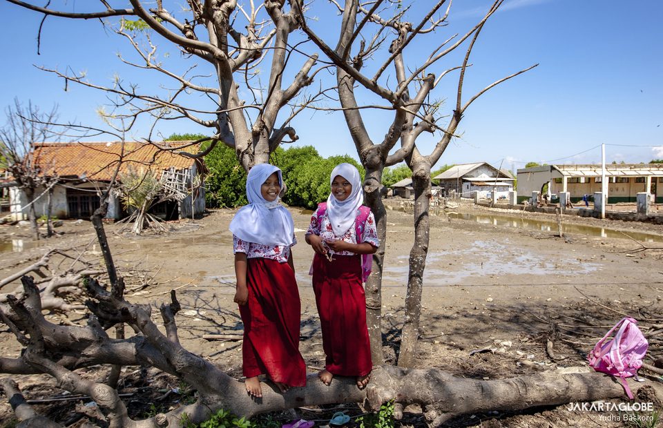 Two elementary school students stand outside their sinking school at Kampong Beting in Bekasi, West Java on September 16, 2021. (JG Photo/Yudha Baskoro)