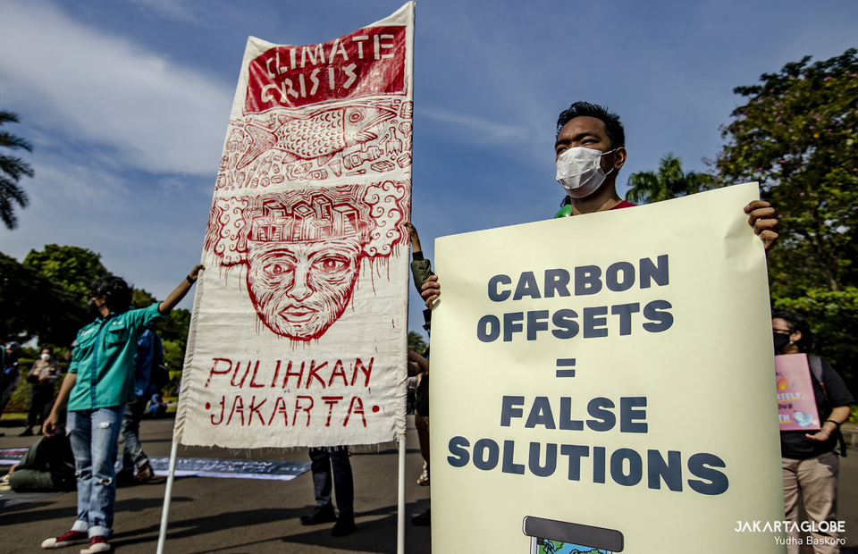 Environmental activists carry placard during a protest against climate change in front of Arjuna Wijaya horse statue in Central Jakarta on November 5, 2021. (JG Photo/Yudha Baskoro)