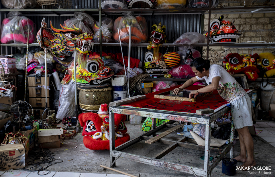 A craftman prepares a fabric to create a new Liong costume at a workshop in Bogor, West Java on January 15, 2022. (JG Photo/Yudha Baskoro)