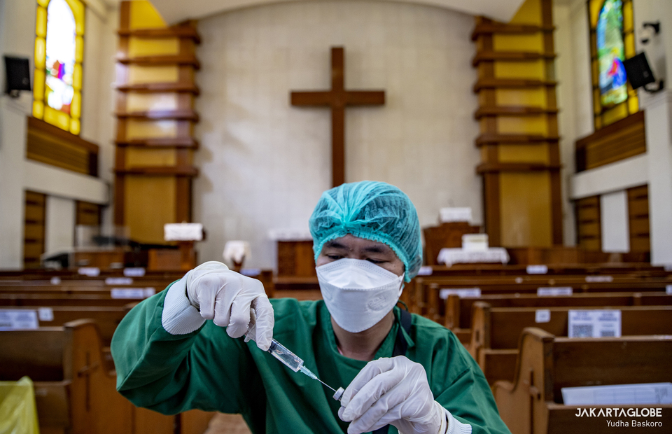 A health worker prepares a booster dose during a mass Covid-19 vaccination program that is held at a HKBP Menteng church at Central Jakarta on February 3, 2022. (JG Photo/Yudha Baskoro