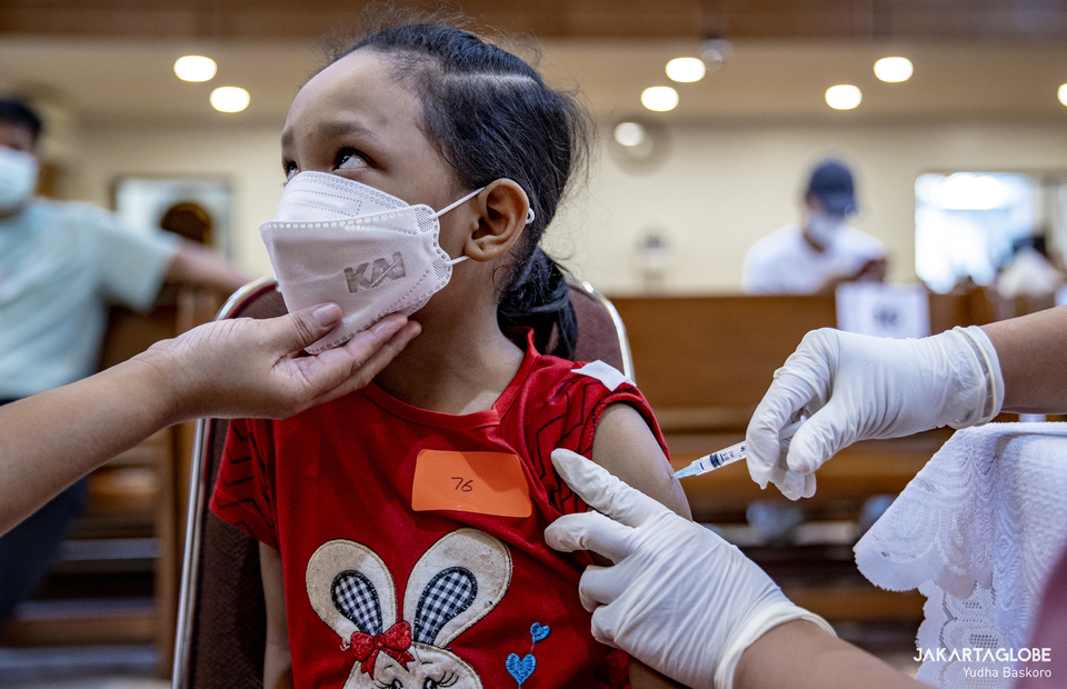 A child reacts as she receives booster dose during a mass Covid-19 vaccination program that is held at a HKBP Menteng church at Central Jakarta on February 3, 2022. (JG Photo/Yudha Baskoro