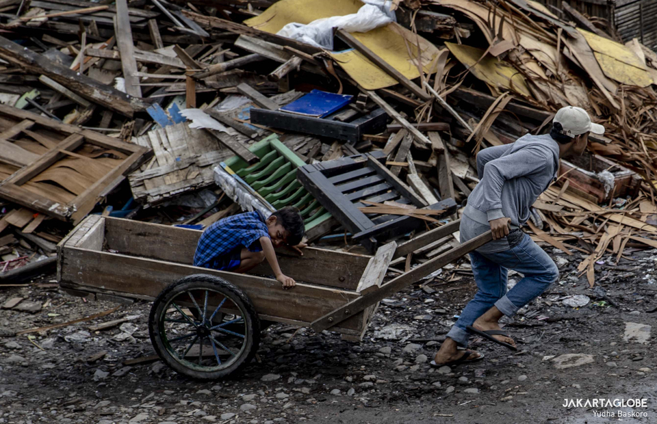 A man pulls a crate at Kali Baru Village, Cilincing, North Jakarta on March 2, 2022. (JG Photo/Yudha Baskoro)