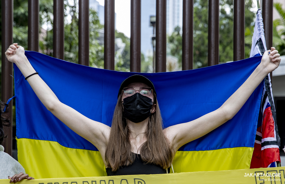 Protester carries Ukrainian flag during protest against Russian Invasion of Ukraine in front of Embassy of the Russian Federation building in Central Jakarta on March 4, 2022. (JG Photo/Yudha Baskoro)
