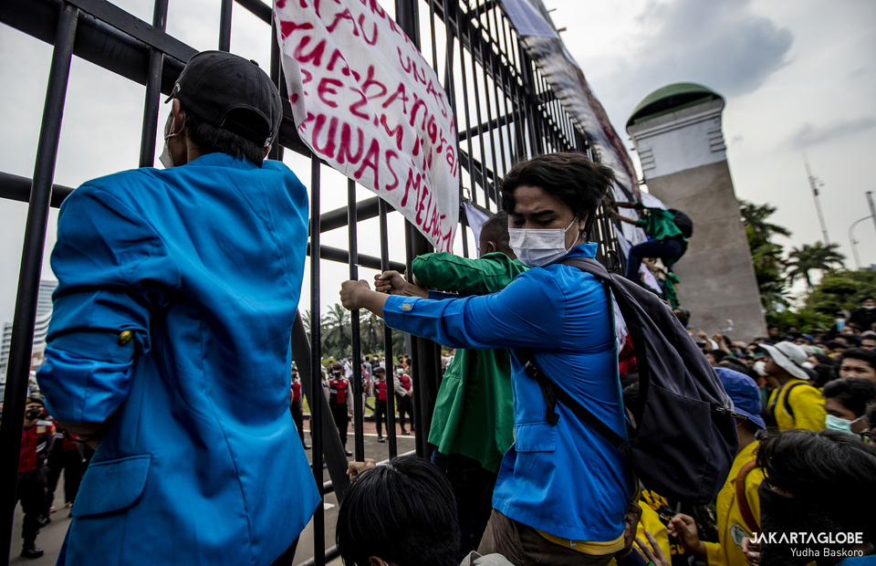 Students climbs the gate of House of Representative during protest in front of House of Representative in Central Jakarta on April 11, 2022. (JG Photo/Yudha Baskoro)