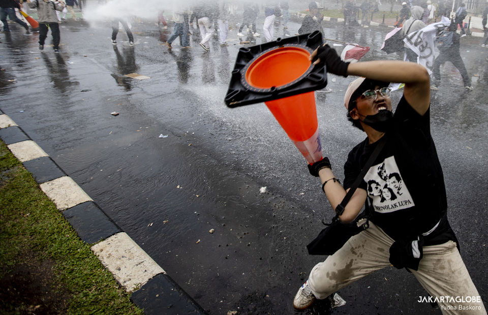 Protester throws a cone during protest in front of House of Representative in Central Jakarta on April 11, 2022. (JG Photo/Yudha Baskoro)