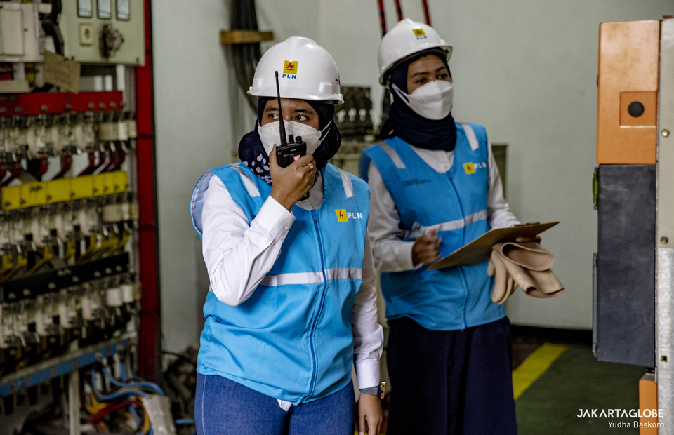 A woman technician talks on her handy talky during assignment at the electrical substation in Jalan M.H. Thamrin, Central Jakarta on April 20, 2022. (JG Photo/Yudha Baskoro)