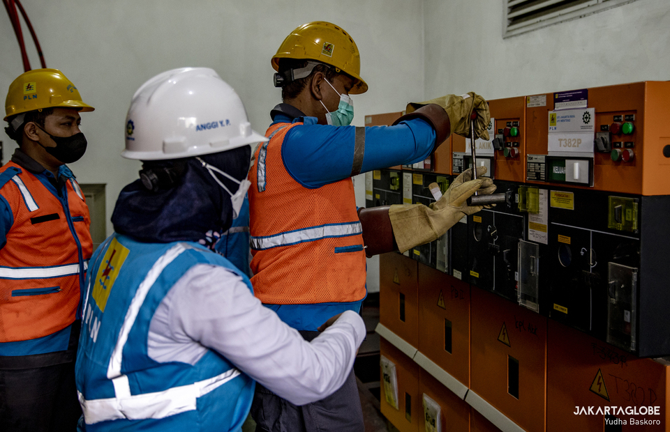 A woman technician oversee her co-worker during assignment at the electrical substation in Jalan M.H. Thamrin, Central Jakarta on April 20, 2022. (JG Photo/Yudha Baskoro)