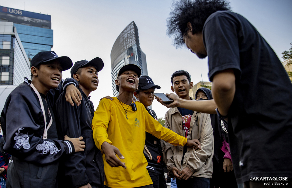 An Indonesian content creator interviews some youth from Citayam during Citayam Fashion Week at the Dukuh Atas area in Central Jakarta on July 19, 2022. (JG Photo/Yudha Baskoro)