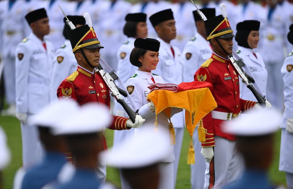 I Dewa Ayu Firsty Meita Dewanggi, center, a member of the elite national flag raiser team, or Paskibraka, carries the flag during the ceremony to commemorate the 77th Indonesian anniversary at the State Palace in Jakarta on August 17, 2022. (Antara Photo/Sigid Kurniawan)