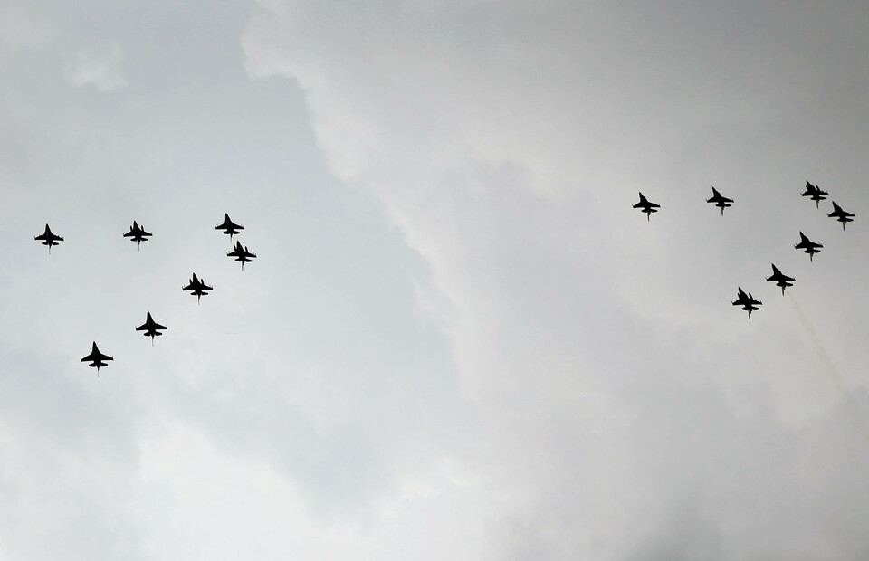 A parade of 14 F-16 Fighting Falcon jetfighters belonging to the Air Force fly above Jakarta shortly after the flag-raising ceremony of Independence Day at the State Palace on August 17, 2022. (Joanito De Saojoao) 