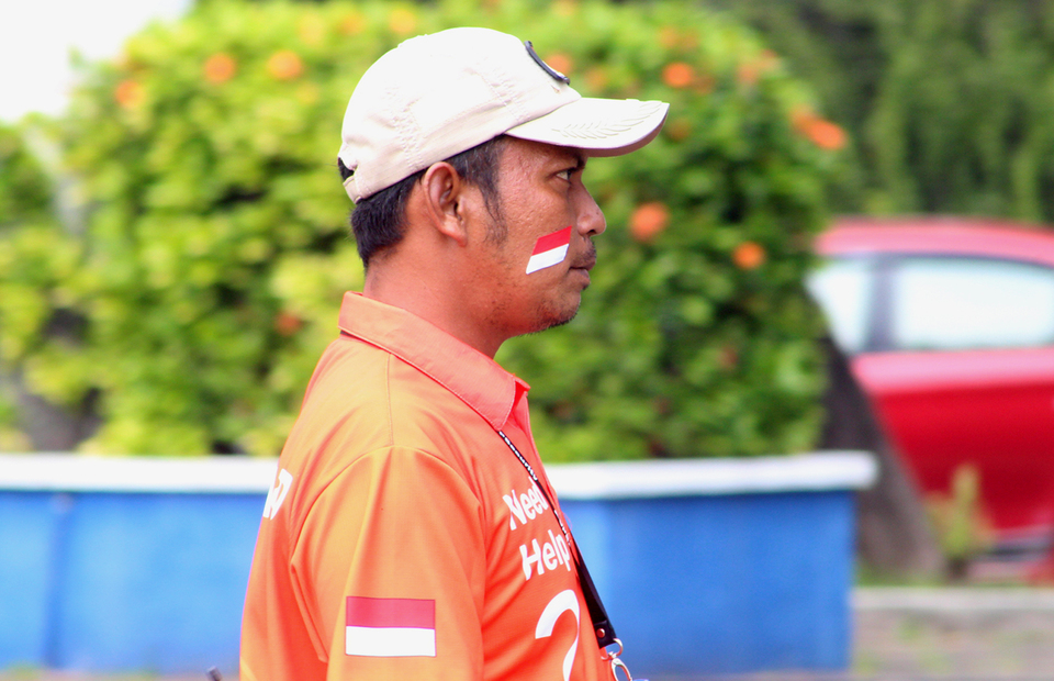 An employee of Ancol Amusement Park in North Jakarta paints the national flag on his face during Independence Day on August 17, 2022. (Emral Firdiansyah)
