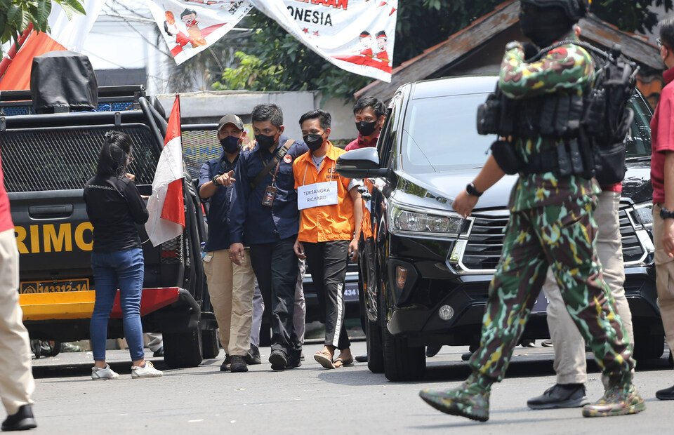 Murder suspect Richard Eliezer, dressing in an orange detainee suit, arrives at Duren Tiga housing complex in South Jakarta on August 30, 2022, to reenact the murder of police officer Nofriansyah Yosua. (Antara Photo/Asprilla Dwi Adha)
