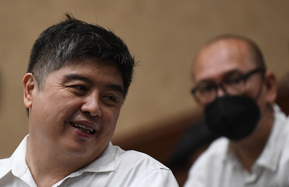 Market analyst Lin Che Wei, left, and CPO company Musim Mas general manager Pierre Togar Sitanggang wait for trial at the Central Jakarta District Court on August 31, 2022. (Antara Photo/Sigid Kurniawan)