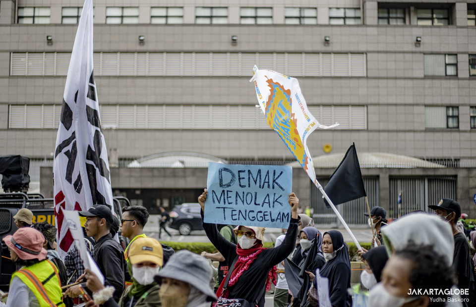 Protester carries a placard that said Demak refuse to sink during climate strike in Central Jakarta on September 23, 2022. (JG Photo/Yudha Baskoro)
