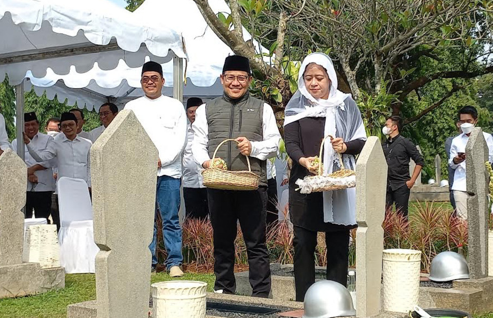 National Awakening Party (PKB) Chairman Muhaimin Iskandar, left, and House of Representatives Speaker Puan Maharani strew flowers on a grave at the Kalibata Heroes Cemetery in South Jakarta on September 25, 2022. (Joanito De Saojoao)