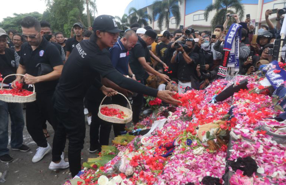 Arema Football Club players and officials strew flowers at the Kanjuruhan Stadium in the East Java town of Malang on Oct. 3, 2022, paying tribute to at least 131 people who died during post-match clashes between fans and security officials in the stadium two days earlier. (Antara Photo)