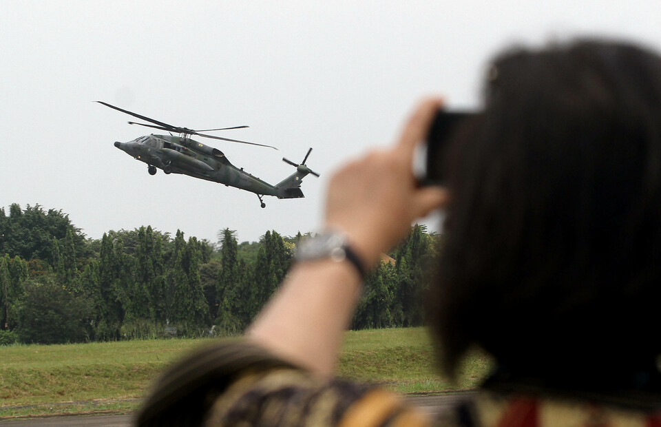 A visitor captures the photo of a US-made S-70 Black Hawk helicopter belonging to the Royal Brunei Air Force during the Indo Aerospace Expo & Forum 2022 at Halim Perdanakusuma Airport in East Jakarta on November 4, 2022. (Joanito de Saojoao)