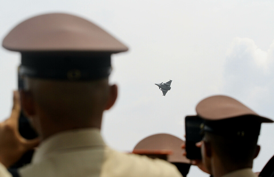Indonesian Air Force cadets watch a French Air Force Rafale jetfighter maneuvering above Halim Perdanakusuma Airport in East Jakarta during the Indo Aerospace Expo & Forum 2022 on November 4, 2022. (Joanito de Saojoao)
