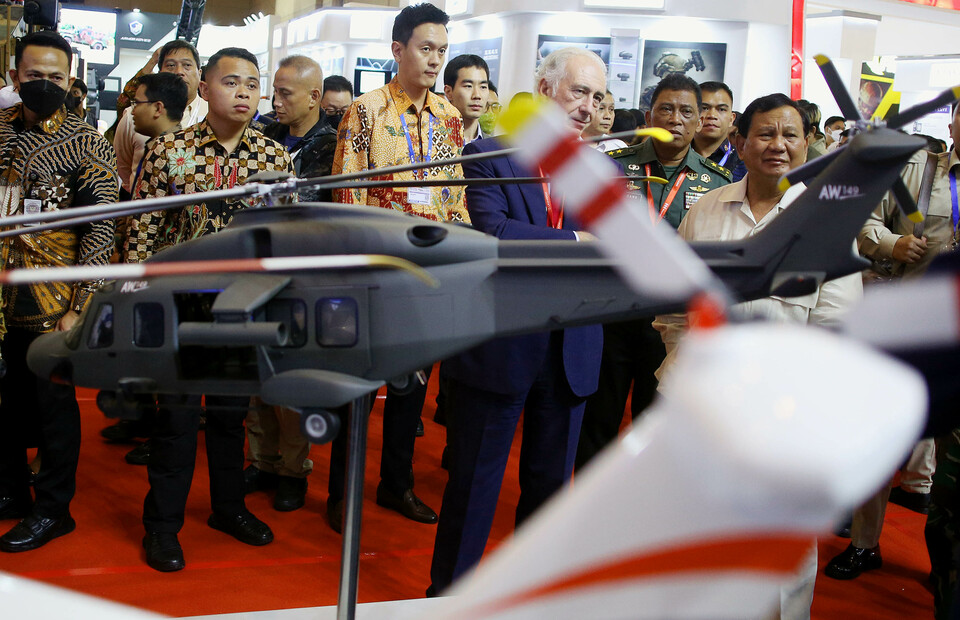 Defense Minister Prabowo Subianto looks at a model of AW149 military helicopter manufactured by Anglo-Italian helicopter manufacturing company AgustaWestland during the Indo Defence arms exhibition in Kemayoran, Central Jakarta, on November 4, 2022. (Joanito De Saojoao)
