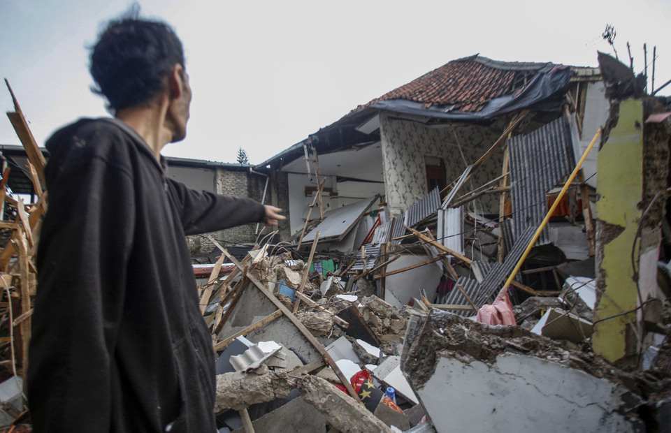 A villager points to his collapsed home after an earthquake that rocked the West Java town of Cianjur on November 21, 2022. (Antara photo/Yulius Satria Wijaya)