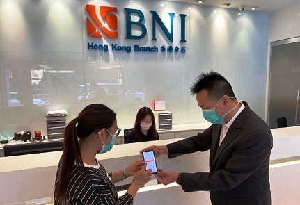 Pegawai sedang membantu nasabah untuk melakukan aktivasi BNI Mobile Banking di Kantor Cabang BNI Hong Kong.