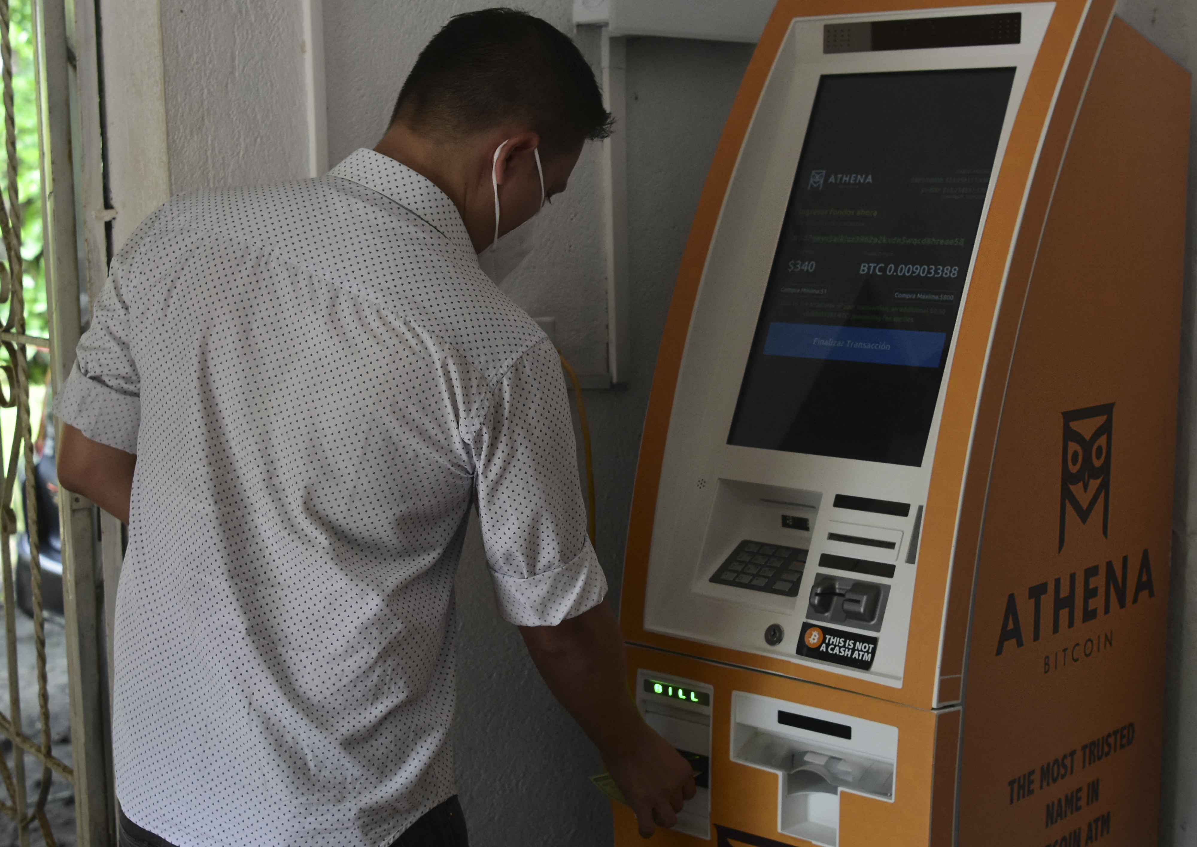 Seorang pria menggunakan ATM bitcoin di wilayah El zonte, 56 km tenggara dari ibu kota San Salvador,  El Salvador, pada 9 Juni 2021. ( Foto: STANLEY ESTRADA / AFP )
