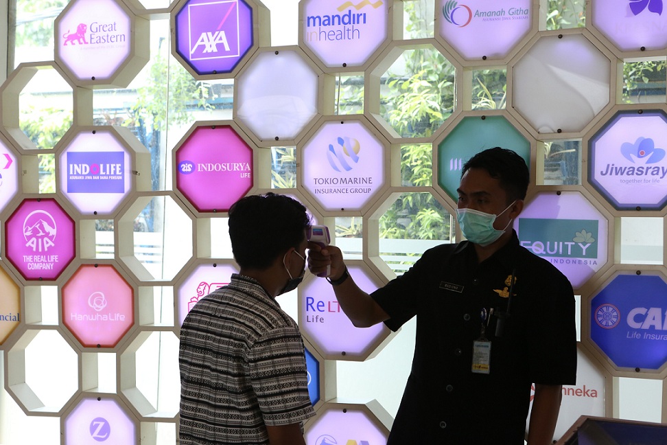 Petugas mengecek suhu karyawan di kantor Asosiasi Asuransi Jiwa Indonesia (AAJI) di Jakarta, beberap waktu lalu. Foto ilustrasi: Beritasatu Photo/Uthan AR