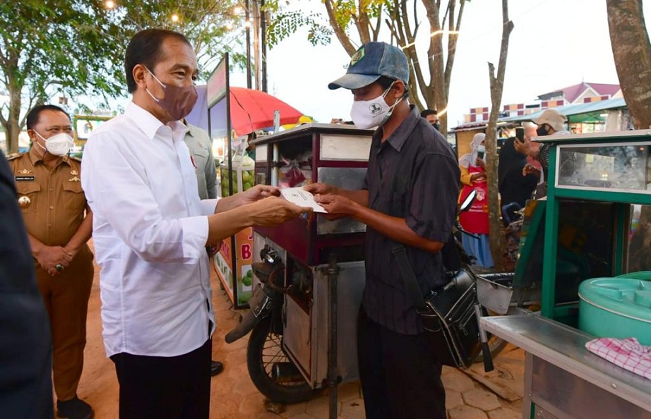 Presiden Jokowi menyerahkan bantuan tunai bagi para pedagang di Taman Batu 10 Kawasan Pasar Bintan Center, Kota Tanjung Pinang, Selasa (25/1/2022). Foto: BPMI Setpres